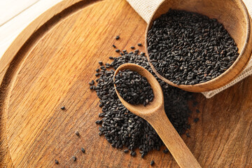 Board with bowl and spoon of black sesame, closeup
