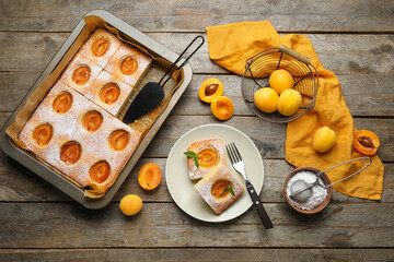 Composition with tasty apricot pie, fresh fruits and sugar powder on wooden background