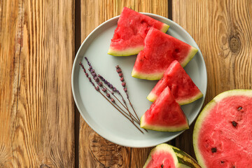 Plate with pieces of juicy watermelon on wooden background