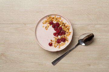 Bowl with granola, yogurt and fresh berries on wooden background, top view