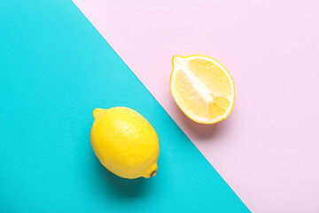 Whole and cut lemons on color background