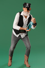 Old pirate with bottle of rum on green background