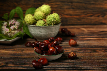 Bowl of fresh chestnuts on wooden background