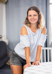 Smiling young girl at home interior, posing on camera