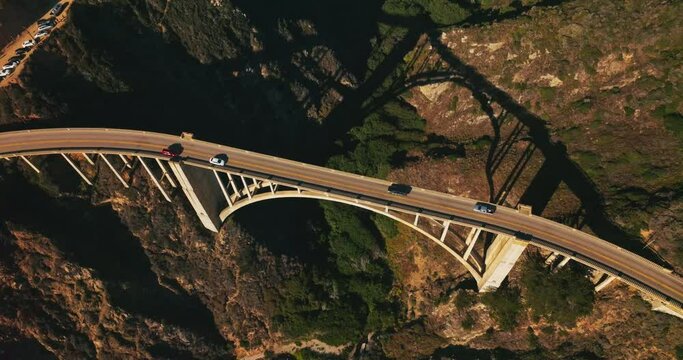 Rising over the bridge with two-lane road for cars. Top view on the gap between the mountains with vegetation growing abundantly there.