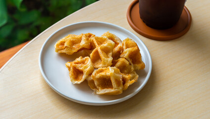 Delicious croissant waffle or croffle on white plate with a  pair of fork, Waffles and Caffles concept, Dessert in cafe concept.  