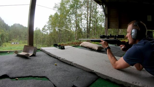 Person laying down to shoot through ballistic chronograph to test bullet speed - Static clip from shooting range with one single person shooting