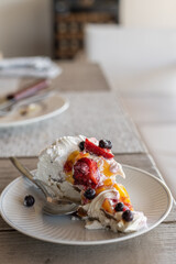 meringue pavlova cake with chantilly cream and red berries