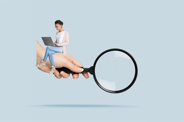 A woman with a laptop and big hand with magnifying glass.
