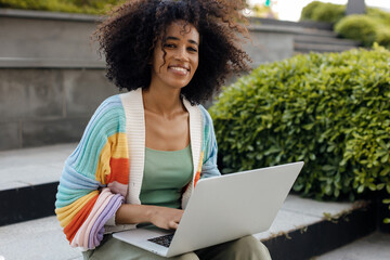 African American female student using laptop outdoor