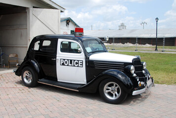 Retro police car in front of barn - 530206507