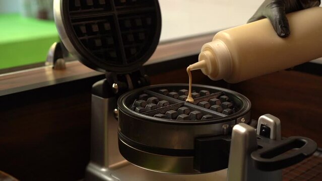 Adding dough to a waffle oster gofrera in slow motion