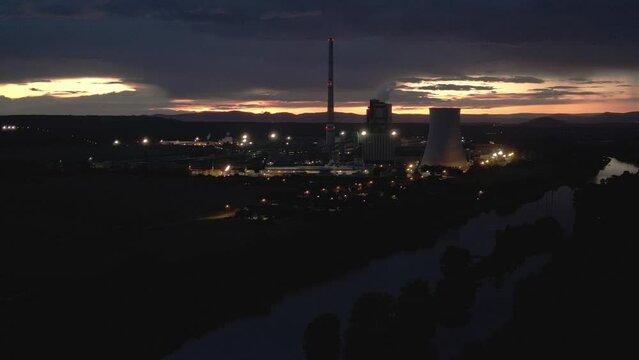 Aerial flight forward for a night view of the coal-fired power plant in Dolni Berkovice. Beautifully lit coal power plant and the panorama of Central Bohemia
