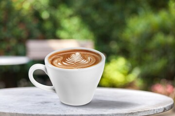 Tasty coffee in a cup on beautiful natural background