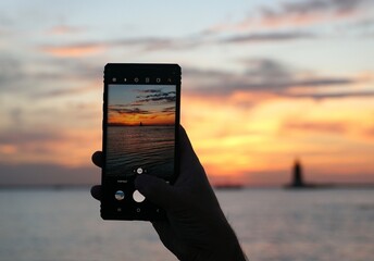 Capturing sunset using a smartphone near Cape Henlopen State Park, Lewes, Delaware, U.S.A © Khairil