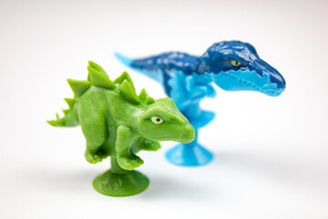 Blue and green dinosaurs toys for children on a white isolated background.Plastic dinosaurs of an ancient era,epoch.