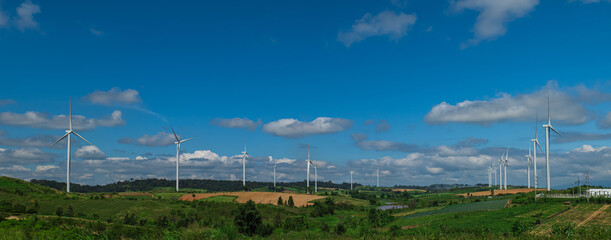 Countryside landscape of hills and turbines field with blue sky cloud background. Windmill Power Farm.