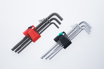 Metal Allen wrench toolkit in plastic holder isolated on a white background. Closeup of hex key set in red toolbox with metric scale and hole for hanging. Steel bolting hand tool kit of various sizes.