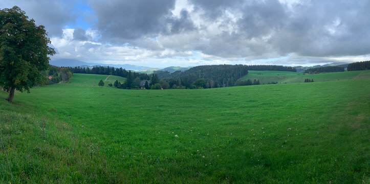 Eine Landschaft im Spätsommer, im Schwarzwald, in Deutschland. Dunkle Wolken sind über der Landschaft zu sehen.