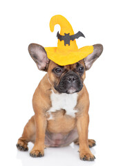 French Bulldog puppy wearing hat for halloween sits in front view. Isolated on white background