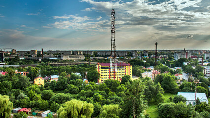 Television tower among the city of Lviv and green plants	
