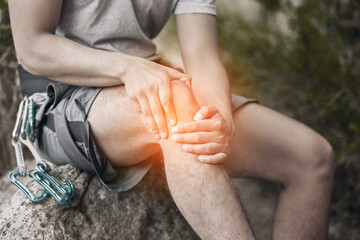 Knee, injury and pain with a man sitting on a rock to take a break while out hiking, rock or...