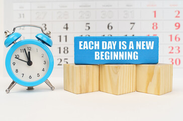 Against the background of the calendar, an alarm clock and a blue block with the inscription Each...
