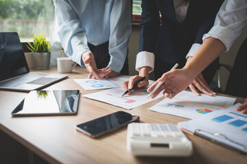 Business team using calculator to calculate the company's financial results and budget. Account...