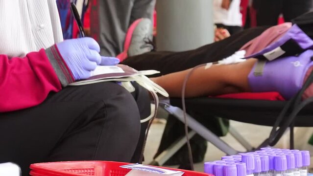 the process of donating blood at a blood transfusion center. Female doctor takes blood sample from patient to test blood content in hospital.