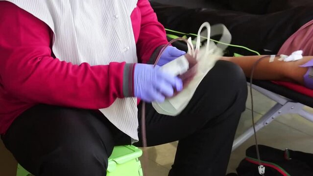 Female doctor takes blood sample from patient to test blood content in hospital. Blood donors to be given to the patient.