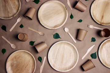 Set of different eco-friendly tableware with green birch leaves on brown paper  background. Bamboo...