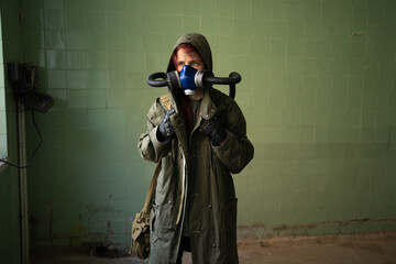 Post apocalypse female survivor in gas mask on wall background. Copy space. Air pollution, environmental disaster