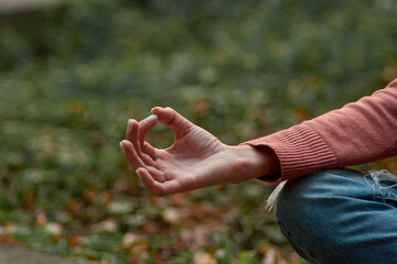 A woman in Casual clothes does yoga in an old park
