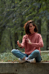 A woman in Casual clothes does yoga in an old park