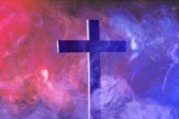 Christian cross with colored smoke, metaphor for moral choices.