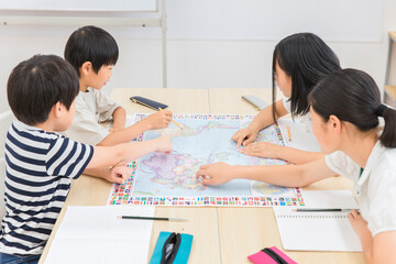 友達と一緒に勉強する子供達（世界地図・社会科）
