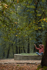 A woman in Casual clothes does yoga in an old park