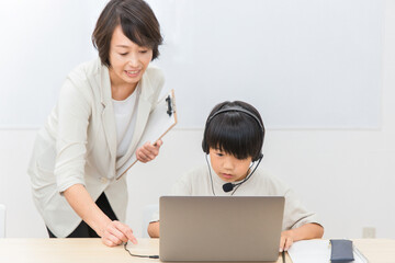 プログラミングスクールで勉強する子供と先生（日本人）
