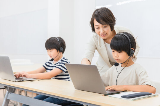 パソコンを使ってICT教育する先生と子供（日本人）
