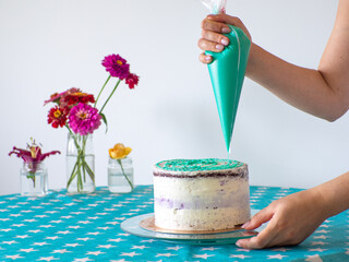 Woman spreading the icing to cover the top of the cake. Home baking, handmade. Free time on...