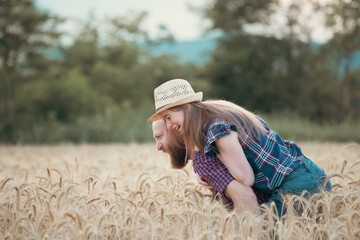 Naklejka na ściany i meble Loving couple in a wheat field.