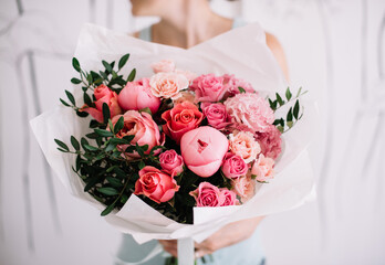 Very nice young woman holding big and beautiful bouquet of fresh peony, roses, carnations, pistachio flowers in pink colors, cropped photo, bouquet close up - 530225705