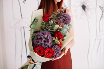 Very nice young woman holding big and beautiful bouquet of fresh alium, roses, eucalyptus  flowers in purple and red colors, cropped photo, bouquet close up - 530225740