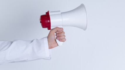 Megaphone in hand. Man wear doctor gown on white background