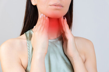 Sore throat in flu season. Young asian woman touching her neck and feeling pain in throat in the...