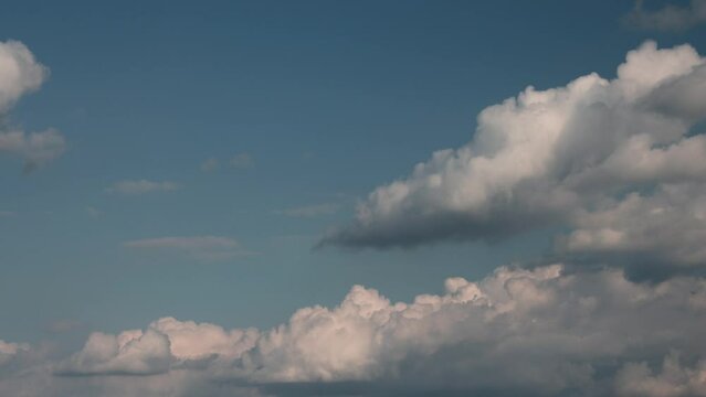 Timelapse of cumulus clouds moving in the blue sky. Light clouds change their shape in cloud space. 