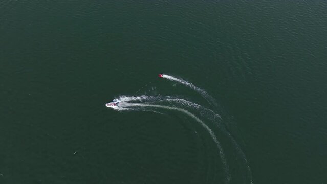 An aerial tracking footage of a wakeboarder and its wakeboat in action at the waters of Haringvliet inlet of the North Sea, in the province of South Holland in the Netherlands.