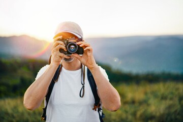 Man with camera on mountain at sunset