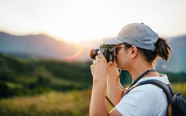 Photographer taking photos on mountain at sunset
