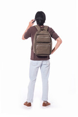 portrait of young man with backpack and using cell phone on white background